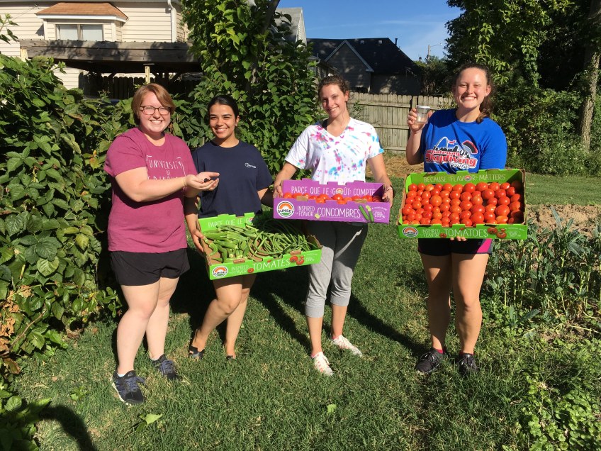 Columbia College students showing garden produce just picked for donation