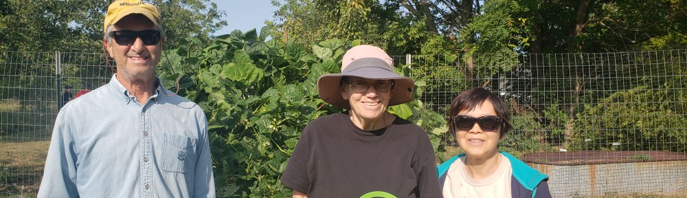 Interfaith garden leaders and volunteers stand in front of their garden